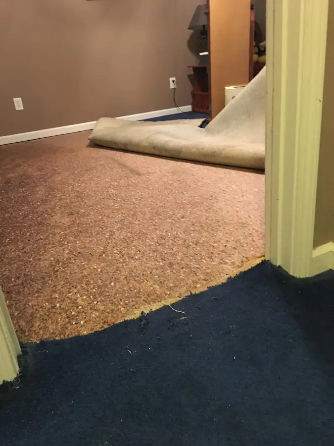 Carpet pad removal revealing water damage during Water Mitigation Services in Kernersville